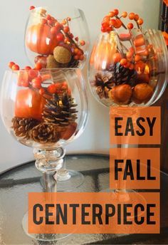 two wine glasses filled with fall decorations on top of a table