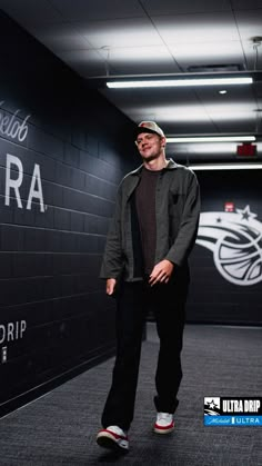 a man standing in front of a wall with the words ultra drip on it,