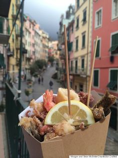 a box filled with different types of food on top of a table next to buildings