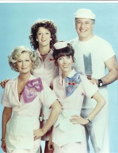 a group of women in pink uniforms posing for a photo with an older man and woman