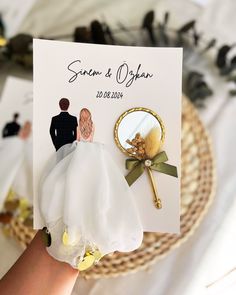 a hand holding a wedding card with a bride and groom on it