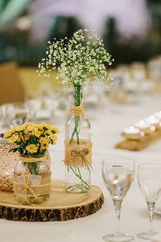 a vase with baby's breath in it sitting on top of a wooden slice