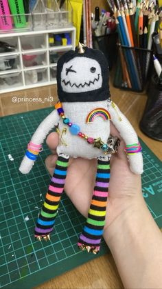 a hand holding a small stuffed toy on top of a table