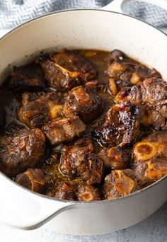 a pot filled with meat and sauce on top of a table