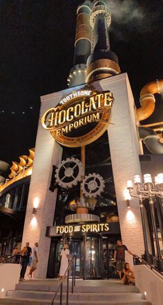 the entrance to chocolate emporum at night with people walking up and down stairs