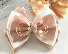 two bows with pearls on them sitting next to each other