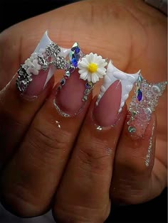 a woman's hand with pink and white nail polishes on it, decorated with flowers