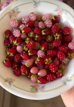 a white bowl filled with lots of strawberries