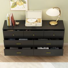 a dresser with several drawers and a lamp next to it