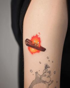 a person with a tattoo on their arm that has an object floating in the air