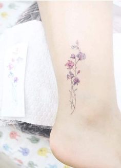 a small flower tattoo on the ankle