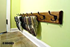 there is a coat rack on the wall with shoes hanging from it's hooks