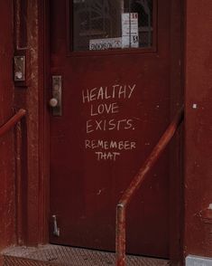 a red door with graffiti on it and the words healthy love existes, remember that