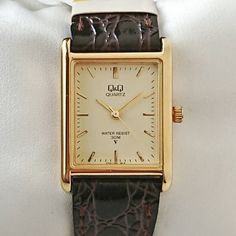 Vintage Q&Q Tank 80s 22x32mm, 18mm lug width. Quartz. Works properly. As is. All original. Unused. The watch has never been used before. The rare rectangular gold tank form makes the watch spectacular. The gold numerals on the perfect beige dial takes attention. The watch is completed with its original dark brown leather strap. Undoubtedly eyecatching. Hard to find another all original Vintage Q&Q Tank in unused condition like this. Only 1. Don't miss.. The watch will be shipped by a reg Seiko Gold, Tank Watch, Vintage Watches For Men, Brown Leather Strap, Square Watch, Beautiful Watches, Dark Brown Leather, 1980s Vintage, Wrist Watches