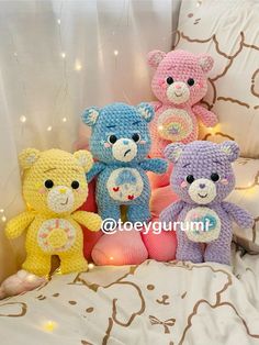 four crocheted teddy bears sitting on a bed