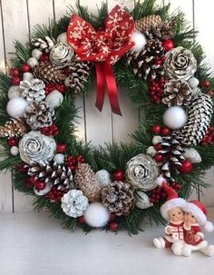 a christmas wreath with pine cones and ornaments