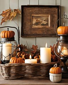 a basket filled with candles and pumpkins on top of a table