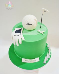 a green cake decorated with a golf ball and glove on top of the cake,