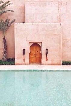 an instagram photo of a pool with a door and palm trees in the background