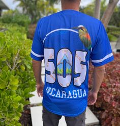 Nicaragua Baseball Jersey in classic blue. This short-sleeve, button-up jersey features high-quality sublimation printing of the Nicaraguan coat of arms on the front, a proudly displayed flag on the sleeve, and the iconic "505" on the back, symbolizing Nicaragua’s roots. Sublimated Coat of Arms Design: Showcases Nicaragua's heritage with vibrant detail. Iconic "505" on Back: Represents Nicaragua’s international calling code. Flag Patch on Sleeve: Adds an authentic touch of national pride. Comfor Blue Short Sleeve T-shirt For Outdoor, Blue T-shirt With Letter Print For Outdoor, Blue Graphic Print Top For Outdoor, Blue Custom Print Shirt For Streetwear, Blue Crew Neck Shirt For Outdoor, Blue Printed Shirt For Streetwear, Casual Blue Short Sleeve Shirt With Graphic Print, Outdoor Blue T-shirt With Letter Print, Printed Light Blue Short Sleeve T-shirt