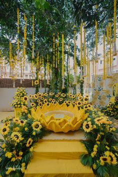 yellow flowers and greenery decorate an outdoor ceremony