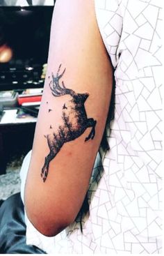 a person with a tattoo on their arm that has a deer and birds on it