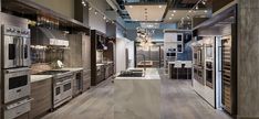 a large kitchen with stainless steel appliances and wood flooring is pictured in this image