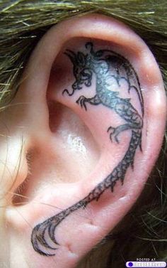 an ear tattoo with a lizard on it