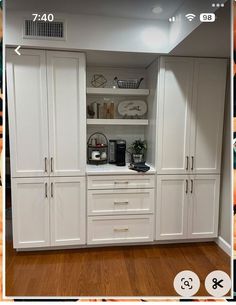 the kitchen cabinets are all white and have no doors on them, but there is also an appliance for cooking