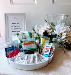 a white tray filled with personal care items on top of a table next to flowers