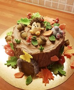 a cake decorated with leaves and animals on a table