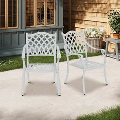 two white chairs sitting on top of a patio