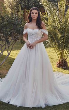 SPRING is a tulle ballgown with ivory and champagne tulle, dust matte lining, Chantilly lace unlined corset bodice, basque waist, attached off-shoulder swag sleeves, and buttons to the end of the train.