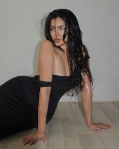 a woman in black dress laying on the floor