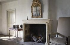 a living room with a fire place and a mirror on the wall next to it