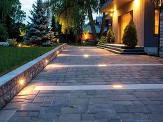 an outdoor walkway with lights on the side and trees in the background