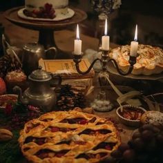 a table topped with lots of pies and candles