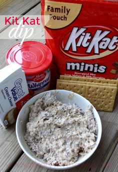 a bowl of food sitting on top of a wooden table next to a bag of kitkat