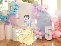 there is a birthday party set up with balloons and princesses on the wall,