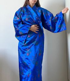 Beautiful, authentic and elegant kimono robe with flower print. No care tag, but fabric feels like satin or silk. Perfect conditions. Fabric is soft, it gives an elegant and sensual look.  Can fit bodies from size S - L. Model is size S, 5'4" tall.  *It does not comes with ribbon* you can use your favorite :) NOTE:  I am a Costume designer, in love with vintage. I just started my store here on Etsy, and I will sell a unique, hight-quality and ready to wear vintage pieces, carefully selected so y Elegant Blue Floral Print Kimono, Blue Floral Print Wrap Kimono, Elegant Blue Robe With Kimono Sleeves, Elegant Blue Wrap Kimono, Blue Silk Long Sleeve Kimono, Blue Kimono For Spring Tea Ceremony, Blue Fitted Long Sleeve Kimono, Fitted Long Sleeve Blue Kimono, Traditional Blue Floral Print Kimono