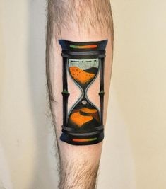 a man's leg with an orange and black hourglass tattoo on his calf