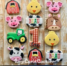 decorated cookies with farm animals and tractors are on a wooden table next to each other