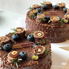 two cakes with chocolate frosting and blueberries on top