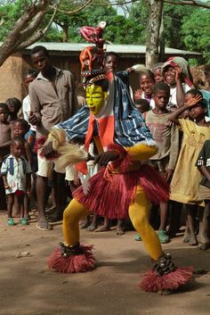 a group of people standing next to each other in front of a man wearing a costume