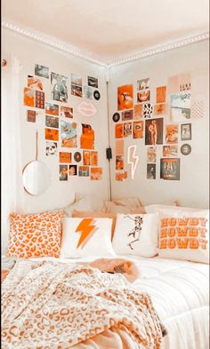 an orange and white bedroom with lots of pictures on the wall above the headboard