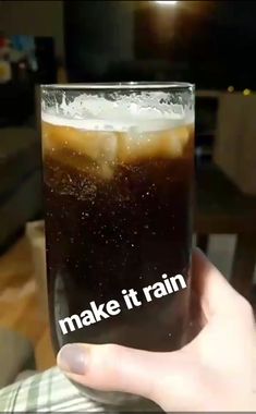 someone holding up a glass with liquid in it that says make it rain on the inside