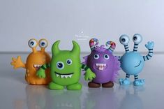 five toy monsters are lined up in a row