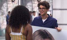 a man holding a sign with a woman in front of him