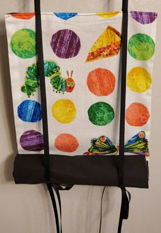 the very hungry caterpillar is hanging on the wall in front of the bag