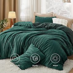 the comforter is green and has two pillows on it, along with other items